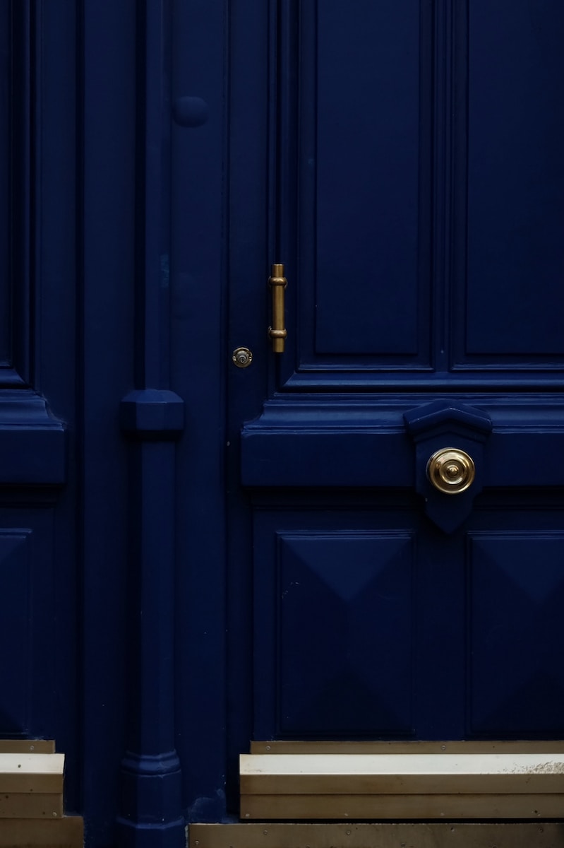 a blue door with a gold handle on it